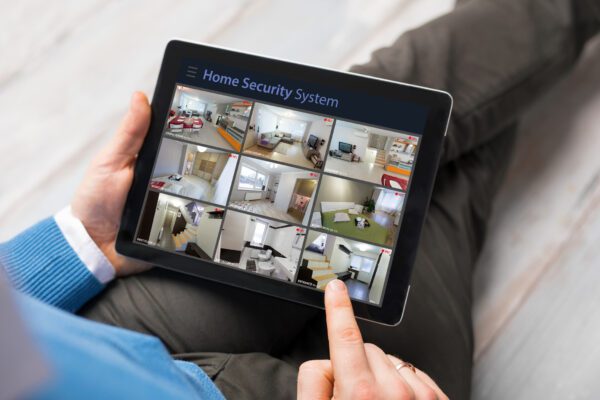 Person checking commercial security application feeds on smartphone